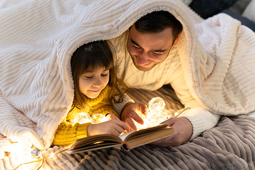 Far og datter læser godnathistorier til børn